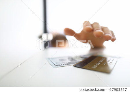 Man's hand reaches for paper bill and card 67903857