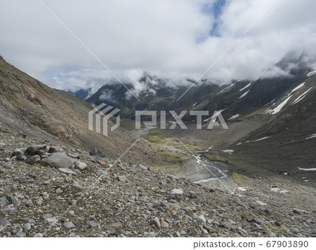 Summer view of alpine mountain valley with winding stream and glacial lake, Sulzenauferner Glacier, Stubai Alps, Austria 67903890