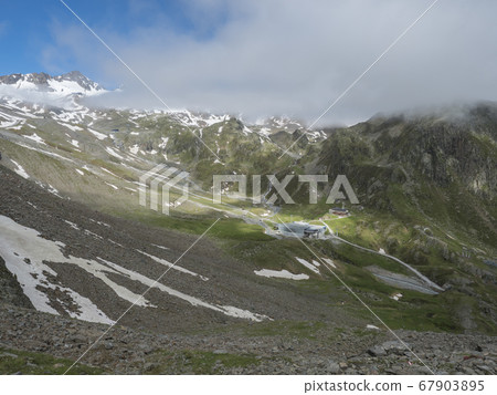 Aerial view on snow spotted mountains with Mittelstation of Stubaier Gletscher cable car station and Dresdner Huette alpine hut. Tyrol, Austria Summer sunny day Aerial view on snow spotted mountains with Mittelstation of Stubaier Gletscher cable car station and Dresdner Huette alpine hut. Tyrol, Austria Summer sunny day 67903895