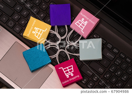 Colorful paper shopping bags put in circle around on notebook keyboard. business concept of online shopping. e-commerce is a transaction of buying or selling products or services online internet. Colorful paper shopping bags put in circle around on notebook keyboard. business concept of online shopping. e-commerce is a transaction of buying or selling products or services online internet. 67904986