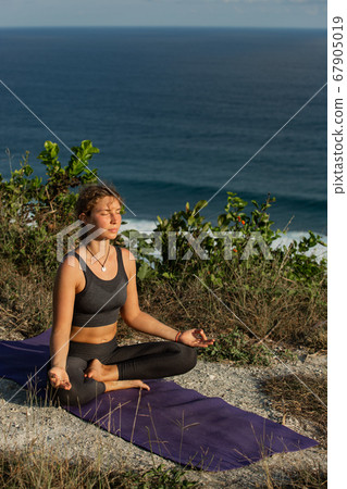 Young woman practicing yoga outdoors Young woman practicing yoga outdoors 67905019