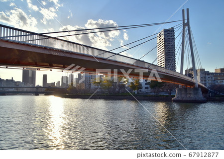 Pedestrian bridge and sunset over Yodogawa, Osaka 67912877