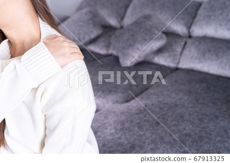 Young woman suffering from neck pain while sitting Young woman suffering from neck pain while sitting 67913325
