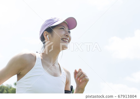 A woman running while listening to music A woman running while listening to music 67913804