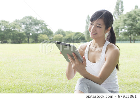 一個女人看著一台平板電腦 一個女人看著一台平板電腦 67913861