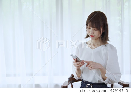 Young woman (see smartphone) 67914743