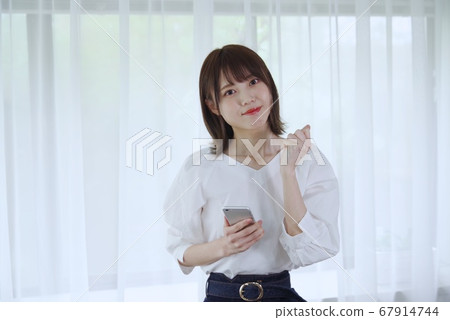 年輕女子(與智能手機擺姿勢) 年輕女子(與智能手機擺姿勢) 67914744