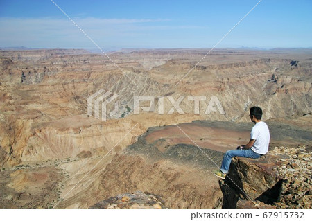 Men standing on the edge of the valley Men standing on the edge of the valley 67915732