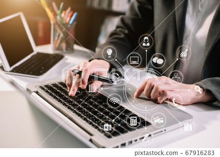 Social media and Marketing virtual icons screen of business women typing keyboard with laptop computer and smart phone at office. Social media and Marketing virtual icons screen of business women typing keyboard with laptop computer and smart phone at office. 67916283