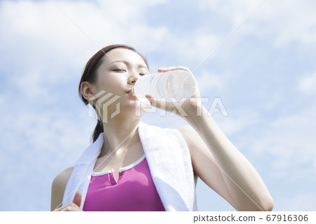 A woman drinking mineral water A woman drinking mineral water 67916306