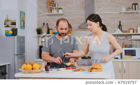 Wife cooking eggs for husband Wife cooking eggs for husband 67919797