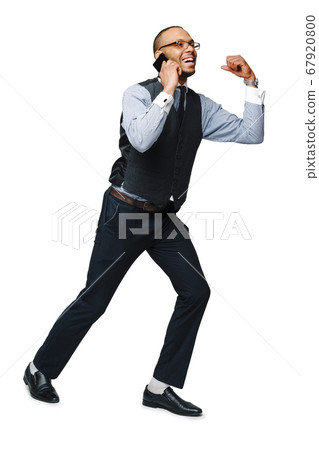 full length studio shot of a african-american businessman talking on the phone gesturing YES WIN Isolated on white background 67920800