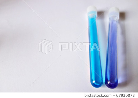在白色背景上垂直放置兩個試管淺藍色和藍色水溶液 在白色背景上垂直放置兩個試管淺藍色和藍色水溶液 67920878