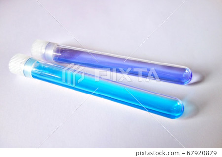 兩個試管水平放置在白色背景上淡藍色和藍色水溶液 兩個試管水平放置在白色背景上淡藍色和藍色水溶液 67920879