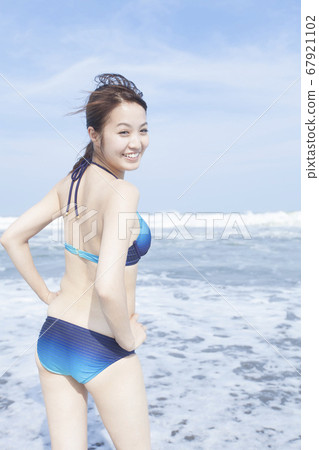 有一張微笑的面孔的一名婦女在游泳衣 有一張微笑的面孔的一名婦女在游泳衣 67921102