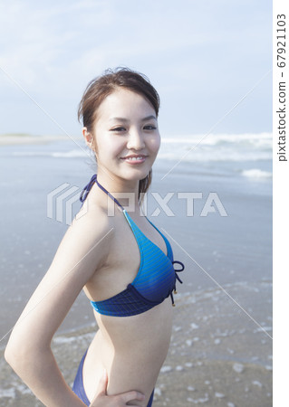 有一張微笑的面孔的一名婦女在游泳衣 有一張微笑的面孔的一名婦女在游泳衣 67921103