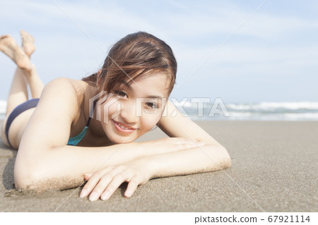 A woman in a swimsuit lying down 67921114