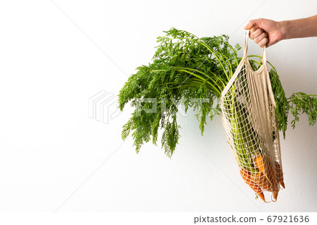 Farmer holds carrot with green leaves Farmer holds carrot with green leaves 67921636