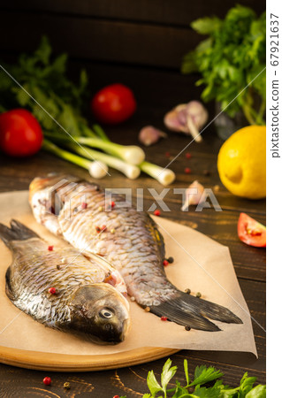 Fresh uncooked carassius on the board Fresh uncooked carassius on the board 67921637