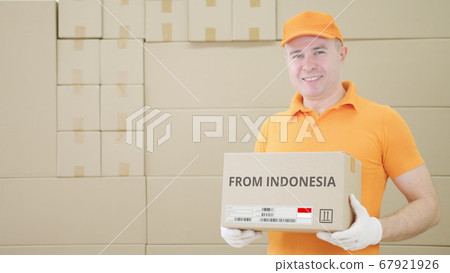 Warehouse worker holds parcel with FROM INDONESIA text on it Warehouse worker holds parcel with FROM INDONESIA text on it 67921926
