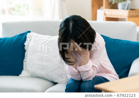 Middle woman who covers her face with anxiety [Living] 67922123