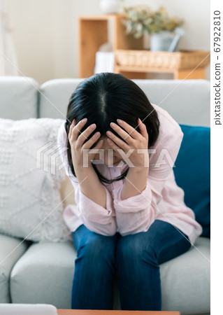 Middle woman who covers her face with anxiety [Living] 67922810