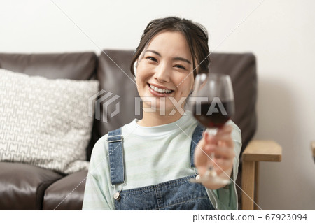 Image of a young woman online drinking party looking at the camera with a wine glass 67923094