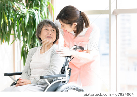 照顧高級女人坐在輪椅上的助手女人 照顧高級女人坐在輪椅上的助手女人 67924004