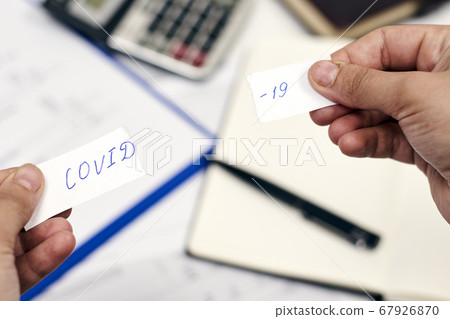 Tearing piece of paper with COVID-19 word 67926870