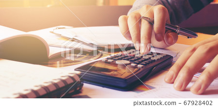 Woman using calculator with doing finance at home 67928402