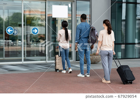 Airport Passengers Standing In Queue To Terminal Entrance With Social Distancing Rules 67929054