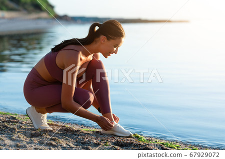 Active sporty woman tying laces of her shoes Active sporty woman tying laces of her shoes 67929072