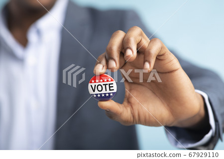 US Elections November 2020 patriotic button in male hand US Elections November 2020 patriotic button in male hand 67929110