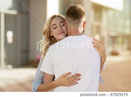 Affectionate couple cuddling, walking down the streets 67929174