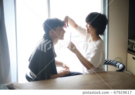 Woman cutting men's hair Woman cutting men's hair 67929617