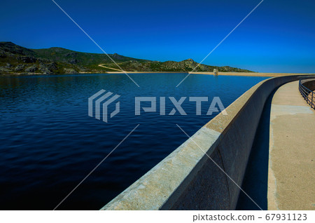 Pathway over dam wall forming a lake on highlands Pathway over dam wall forming a lake on highlands 67931123