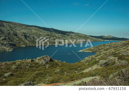 Hilly landscape with lake on highlands Hilly landscape with lake on highlands 67931158