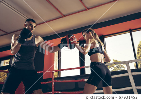 Beautiful young sporty couple training, workout in gym together 67931452