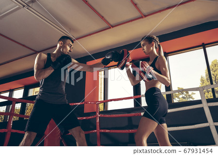 Beautiful young sporty couple training, workout in gym together 67931454