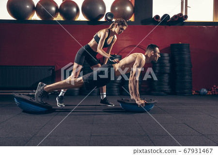 Beautiful young sporty couple training, workout in gym together 67931467