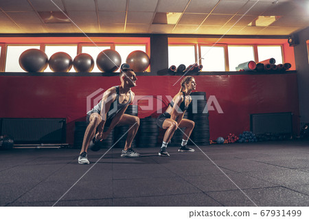 Beautiful young sporty couple training, workout in gym together 67931499
