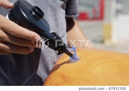 man inflating an orange pool air mattress man inflating an orange pool air mattress 67931508