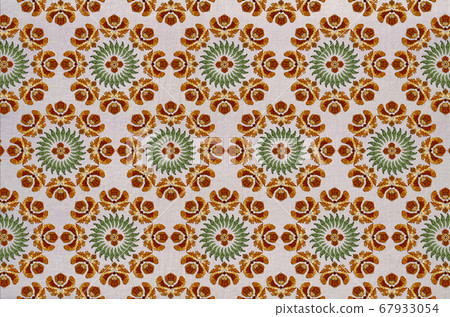Background on fabric of round embroidery with orange flowers, wreath of green leaves and a flower in the center Background on fabric of round embroidery with orange flowers, wreath of green leaves and a flower in the center 67933054