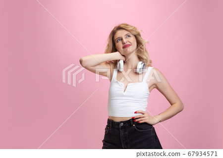 Caucasian young woman's portrait isolated on pink studio background. Beautiful female model. Concept of human emotions, facial expression, sales, ad, youth culture. 67934571