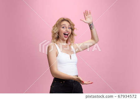 Caucasian young woman's portrait isolated on pink studio background. Beautiful female model. Concept of human emotions, facial expression, sales, ad, youth culture. Caucasian young woman's portrait isolated on pink studio background. Beautiful female model. Concept of human emotions, facial expression, sales, ad, youth culture. 67934572