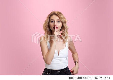 Caucasian young woman's portrait isolated on pink studio background. Beautiful female model. Concept of human emotions, facial expression, sales, ad, youth culture. 67934574