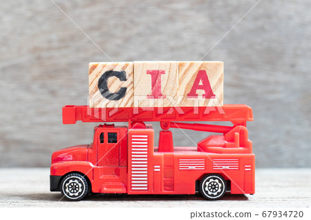 Red fire truck hold letter block in word CIA (abbreviation of certified internal auditor) on wood background 67934720