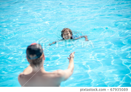 Man with back with outstretched arms to swimming boy Man with back with outstretched arms to swimming boy 67935089