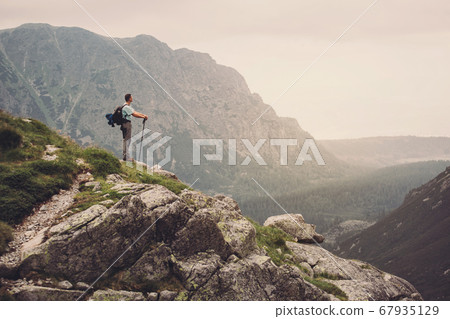 Man Traveler on mountain summit enjoying aerial view. Slovakia, Europe. Man Traveler on mountain summit enjoying aerial view. Slovakia, Europe. 67935129