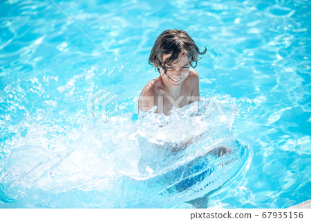 Boy with power vigorously moving hands in water. Boy with power vigorously moving hands in water. 67935156